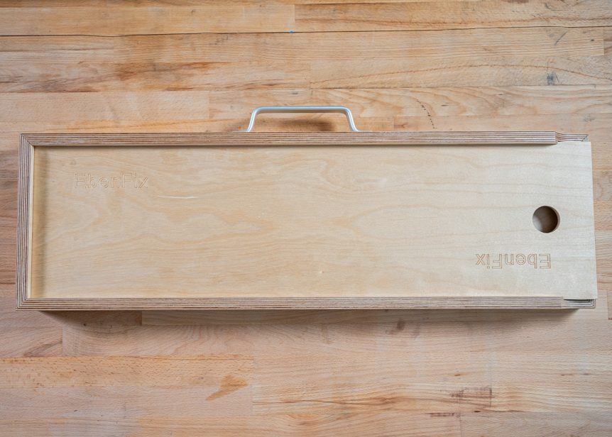 Geschlossener Holzkoffer mit eingraviertem EbenFix-Schriftzug.